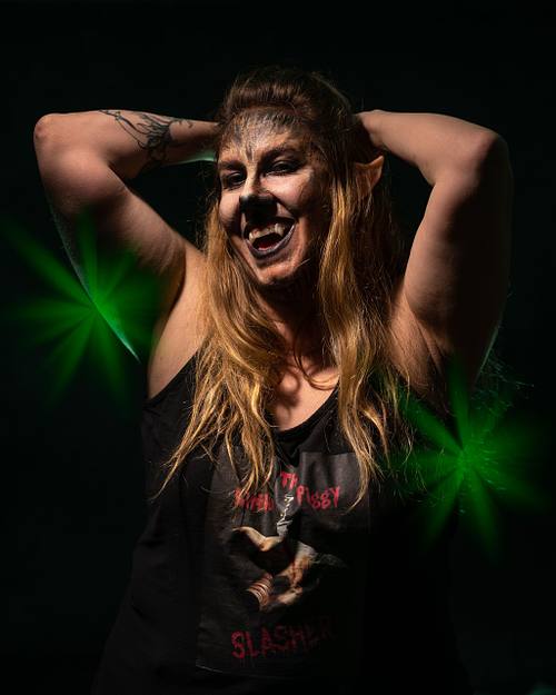 A self-satisfied werewolf raising her arm behind her head with a smirk and is wearing a piggy t-shirt.