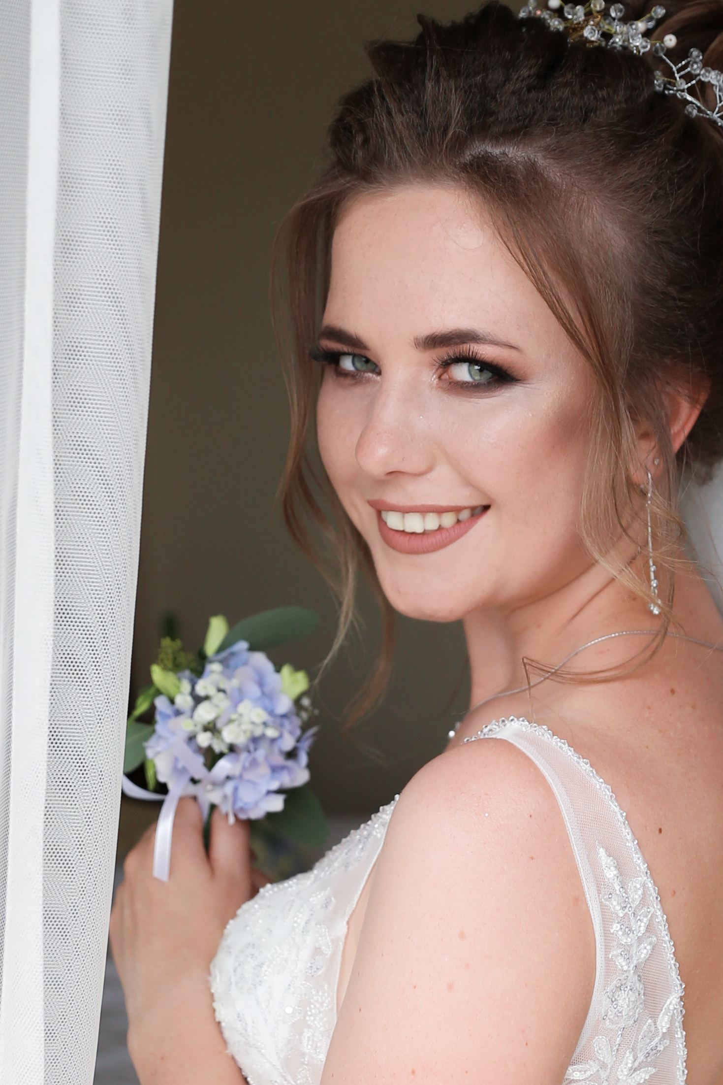 Bridal portrait with blue flowers on her wedding day in Ukraine