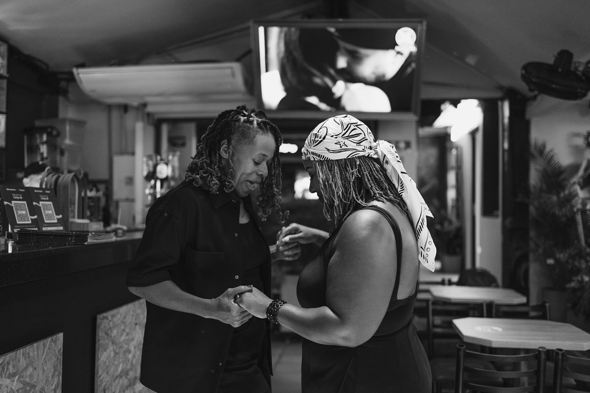 Black and white photo of a couple sharing a quiet moment inside a Medellin bar