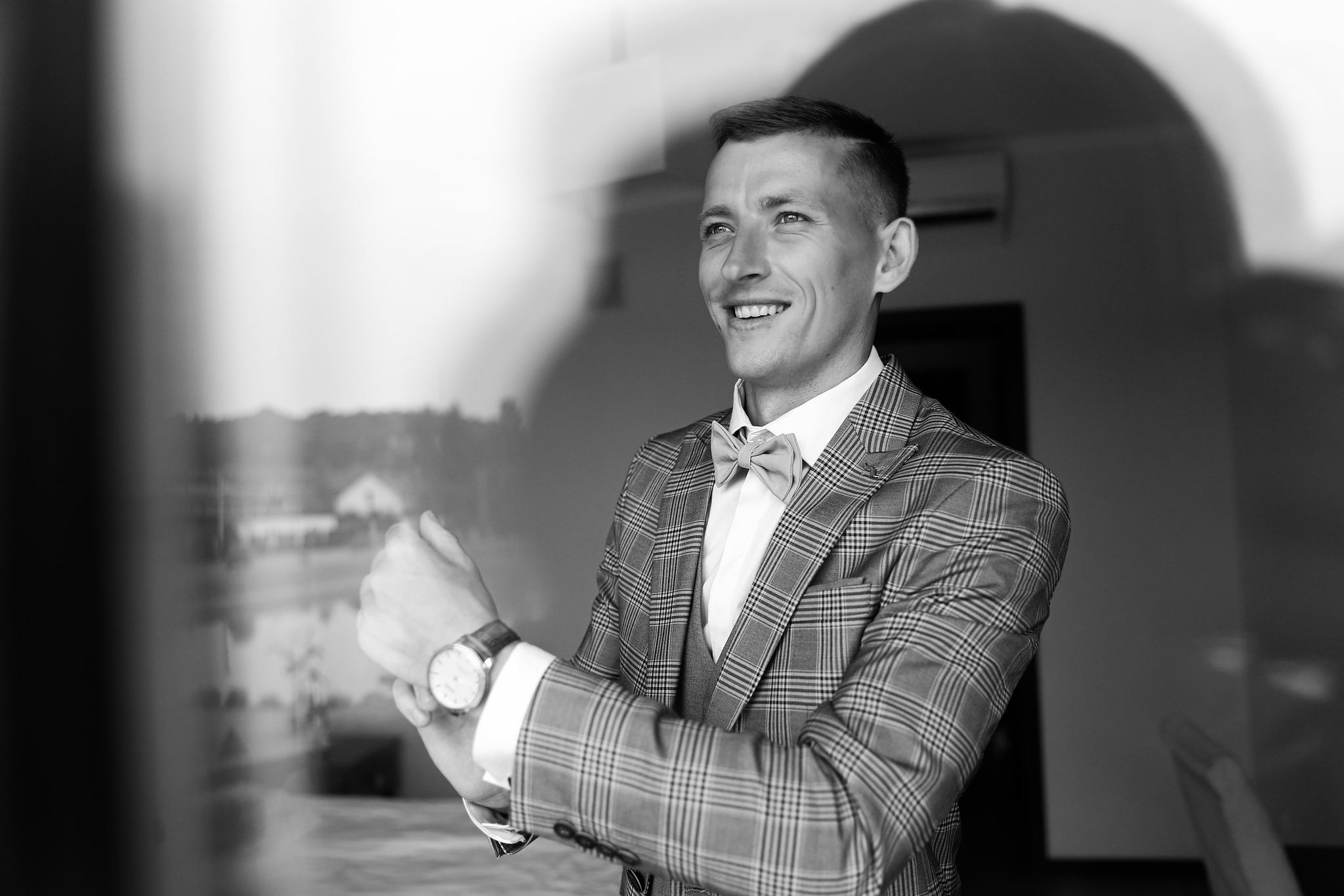 Black and white portrait of the groom getting ready on his wedding day