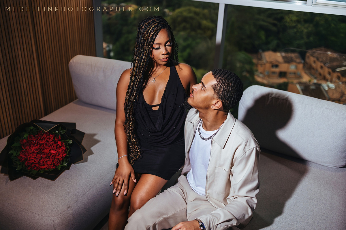 Couple with red roses during a relaxed at home engagement session in a Medellin apartment
