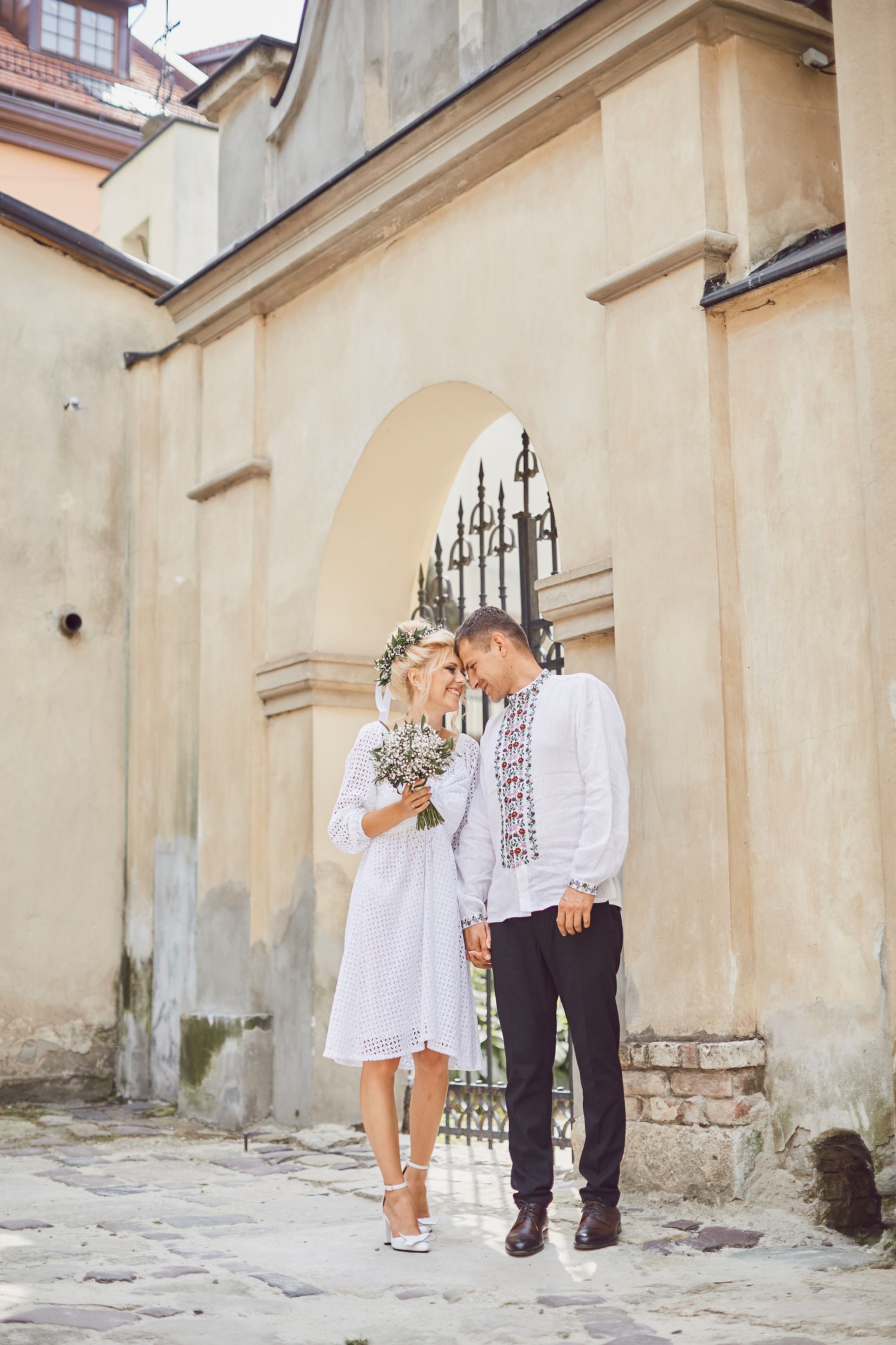 Bride and groom walking together along a quiet street