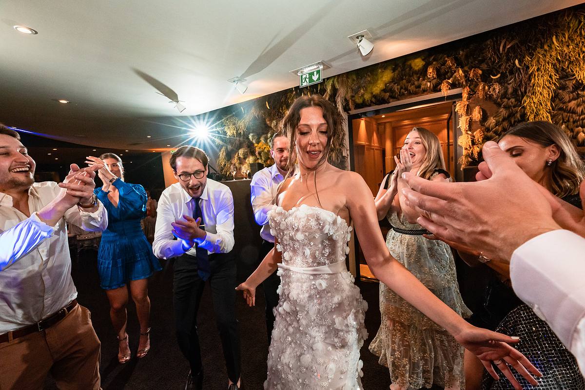 La mari&eacute;e rayonnante, entour&eacute;e de ses proches en liesse, avance parmi les acclamations, immortalis&eacute;e par Sebastien CLAVEL Photographe mariage Lyon dans l'ambiance &eacute;l&eacute;gante du Pavillon du Casino Lyon vert