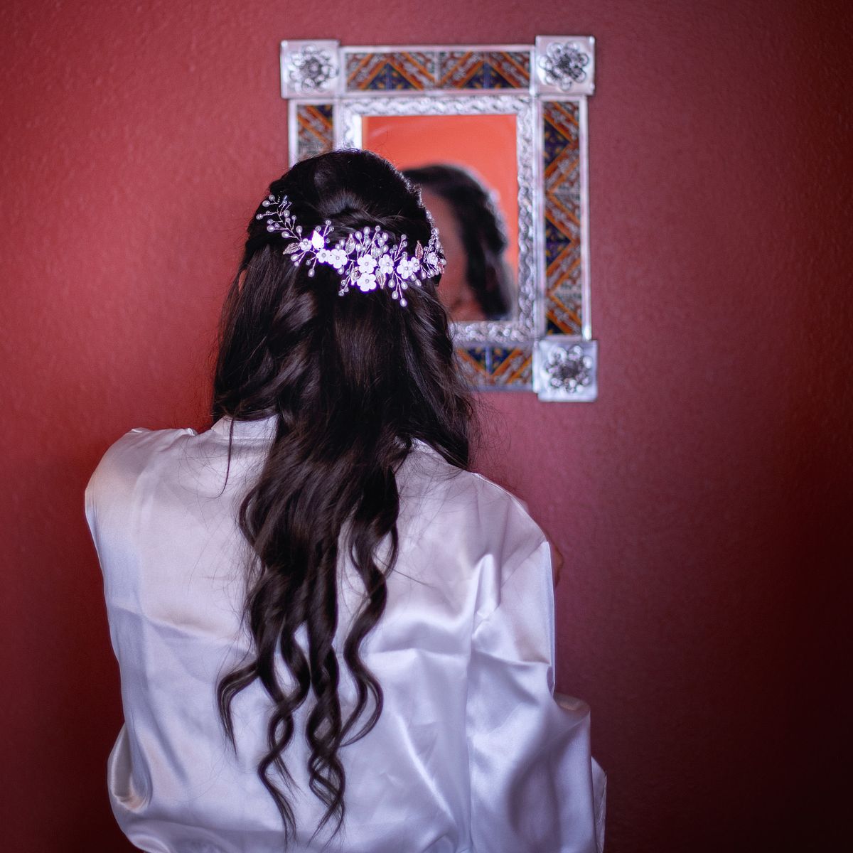 bride taking a look in the mirror showing of her finished wedding hair
