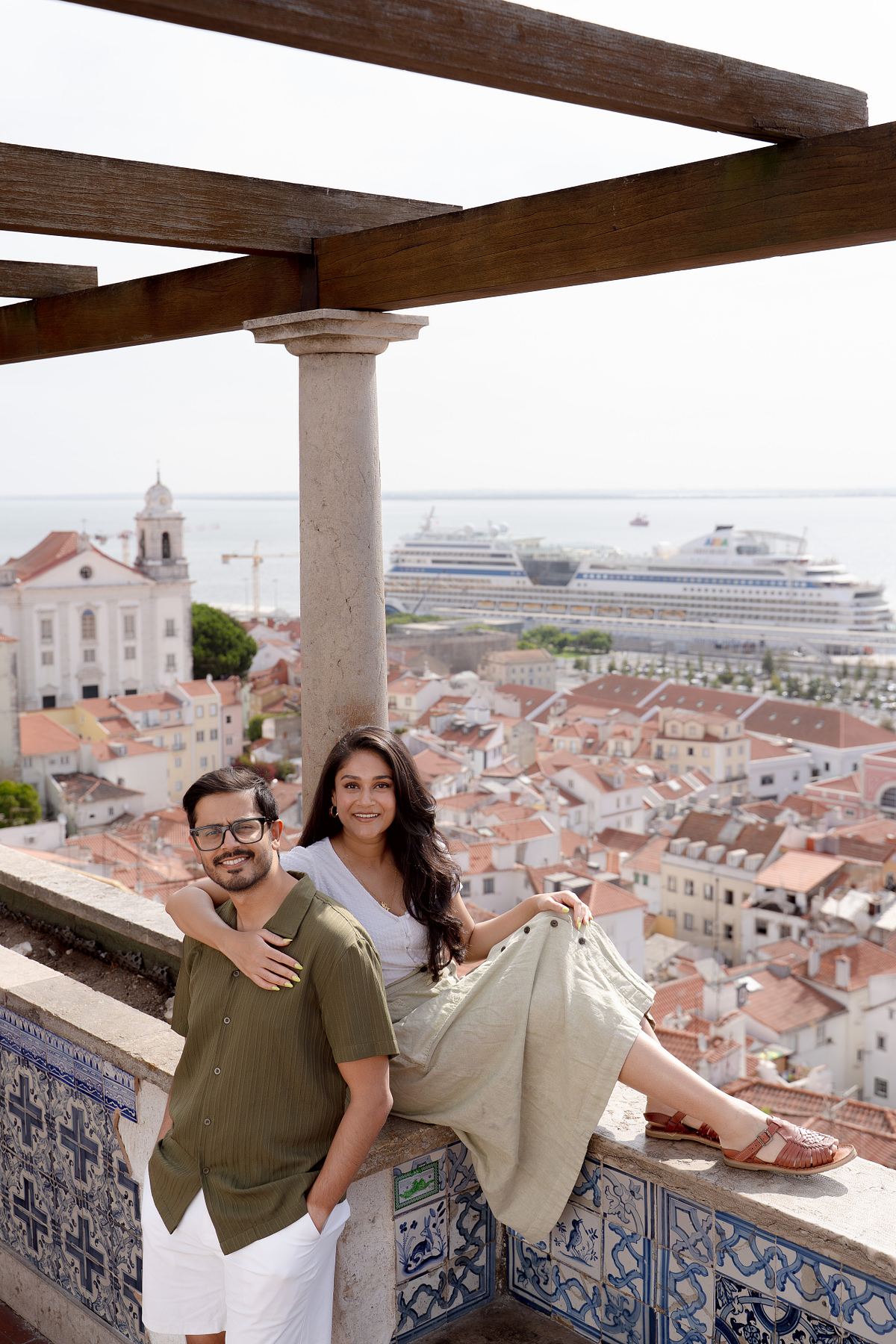 Couple relaxing beneath a pergola overlooking Lisbon