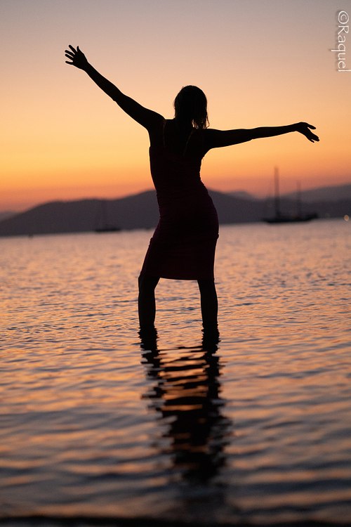 Femme debout dans la mer au coucher du soleil pendant une séance photo portrait à Hyères.