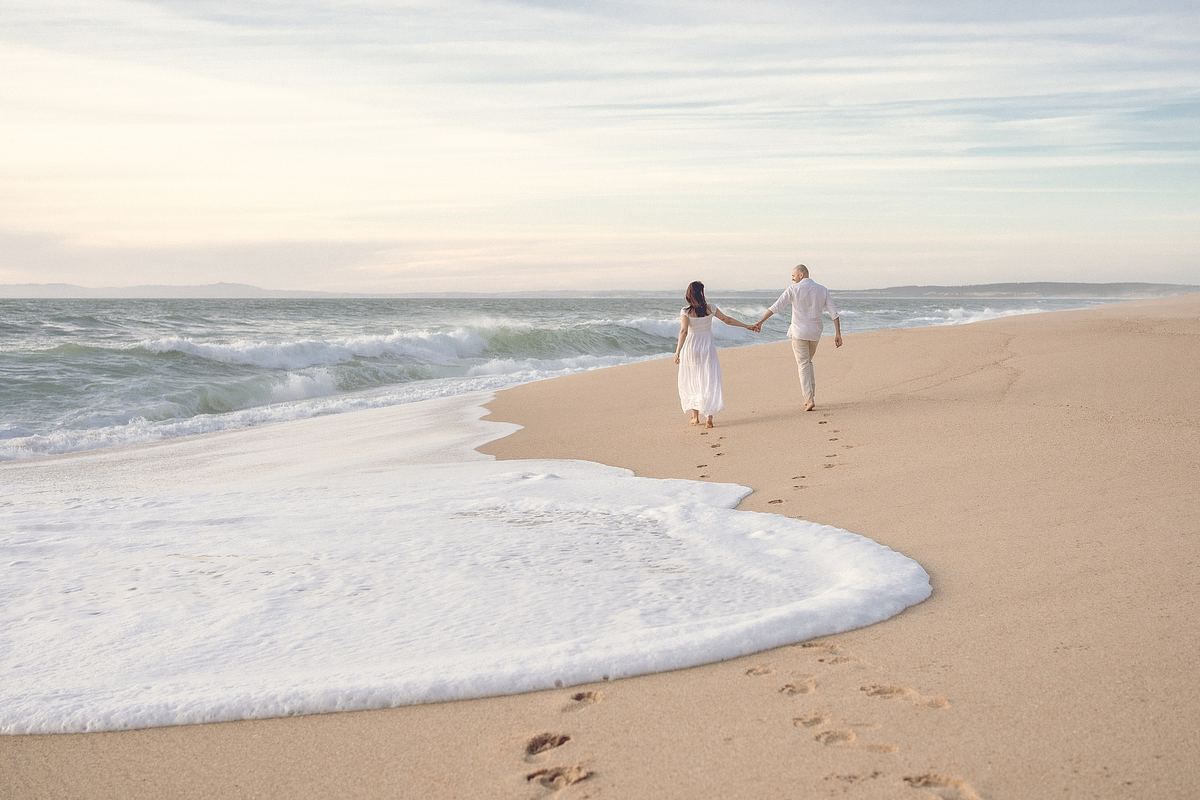 Couple walking along a sandy beach near Lisbon