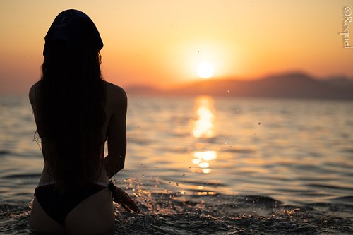 Silhouette féminine de dos face au coucher du soleil sur la Méditerranée à Hyères.