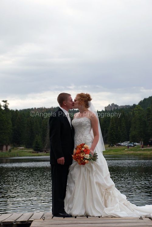A bride and groom share a kiss in front of Sylvan Lake - Custer State Park Wedding Photography