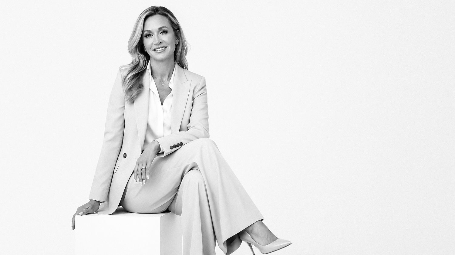 Professional business portrait of a confident woman in a white suit against a light background in Tallinn