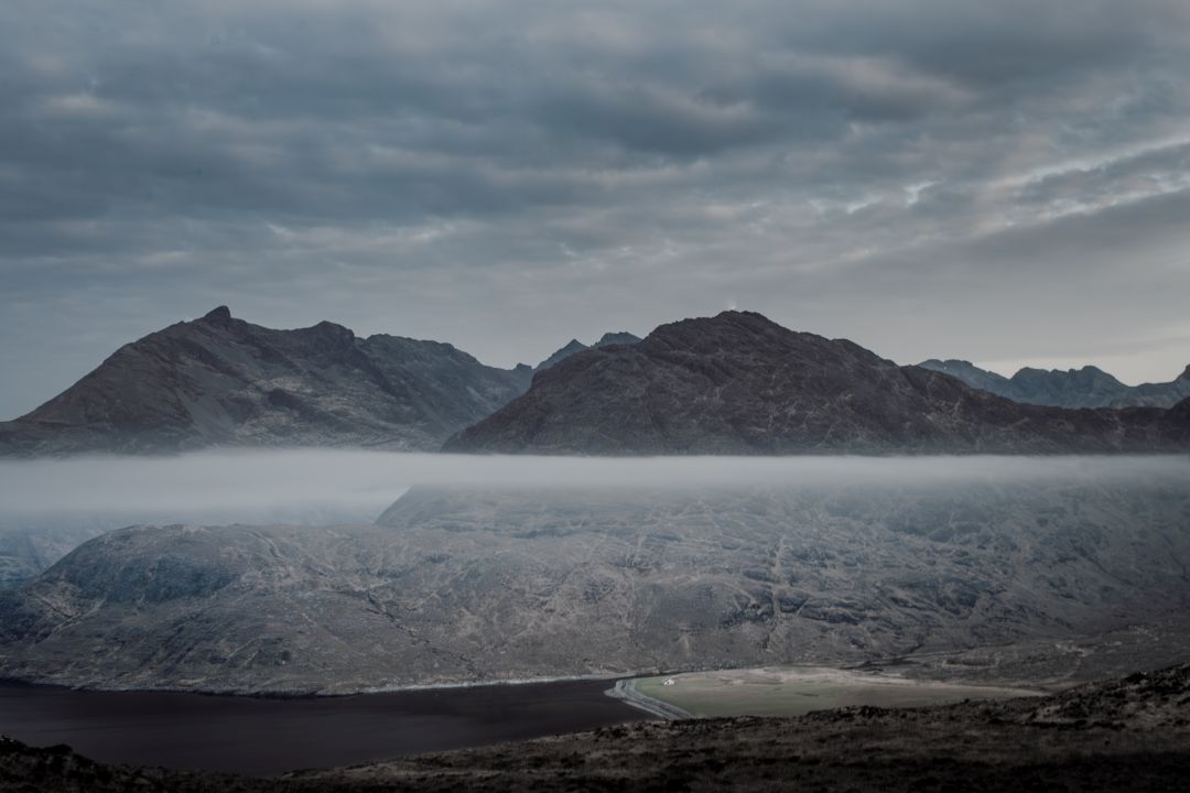 Rugged mountains on the Isle of Skye in Scotland beneath low cloud.