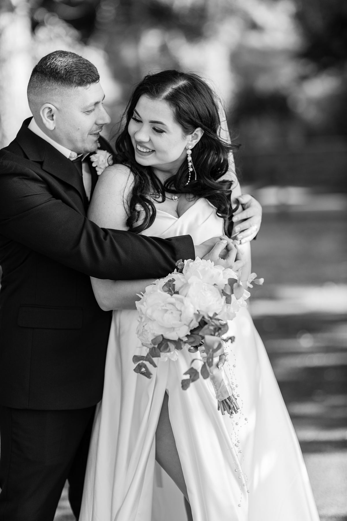 Black and white close portrait of bride and groom embracing outdoors in South Wales