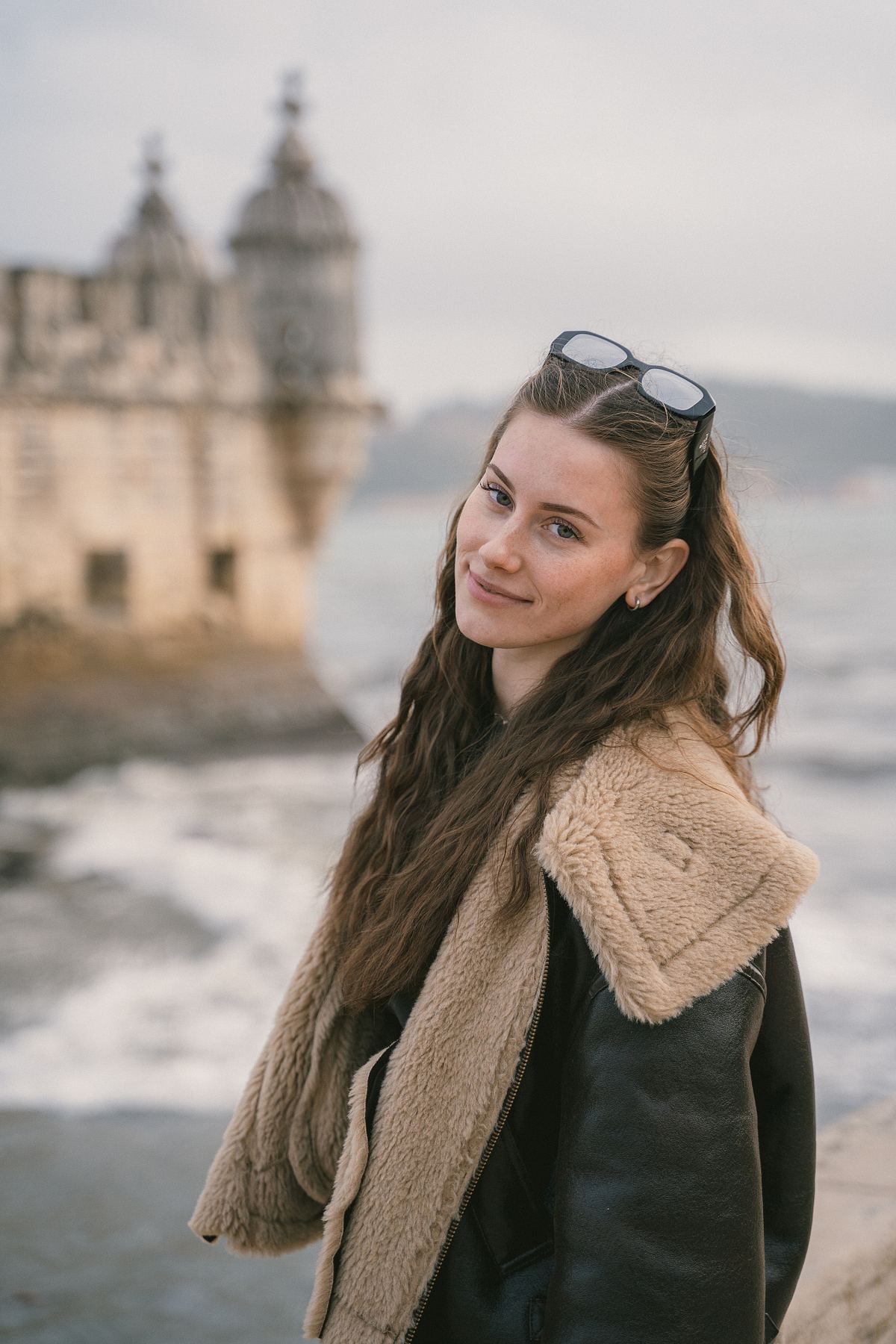 Solo traveler portrait beside Bel&eacute;m Tower in Lisbon