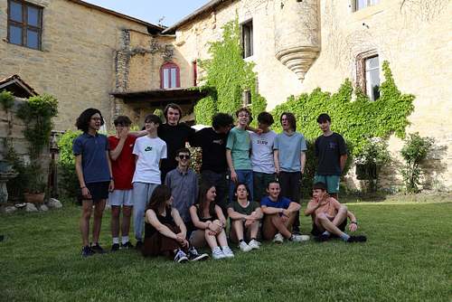 Groupe de jeunes joueurs posant dans la cour verdoyante du Château de Saint-Chamarand. Hébergement de grande capacité pour séjours de vacances et activités ludiques dans le Lot.