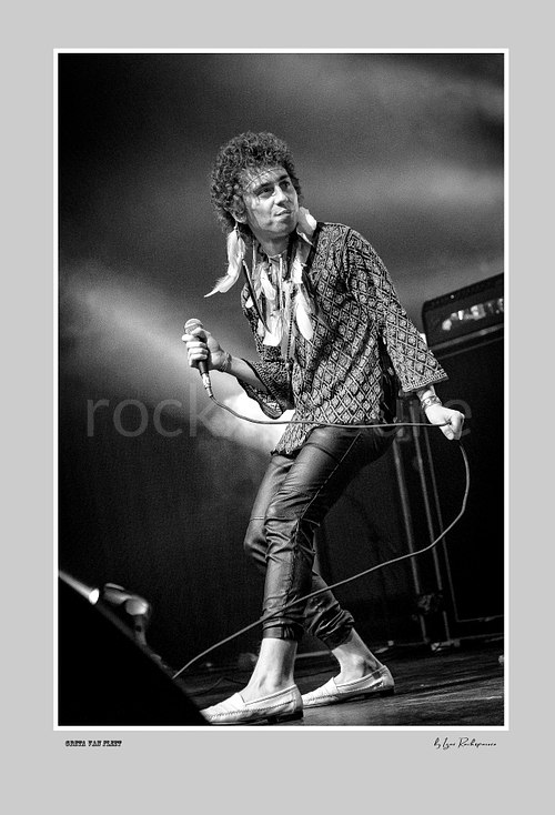 Vertical black and white image of Greta Van Fleet singer Josh Kiszka holding a microphone during a live performance