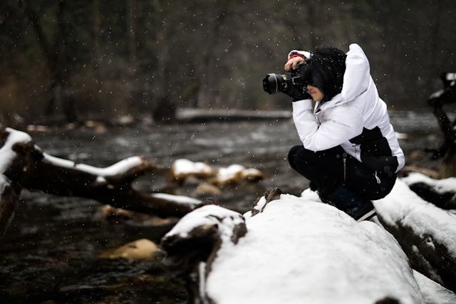 fotografo che scatta foto durante la neve