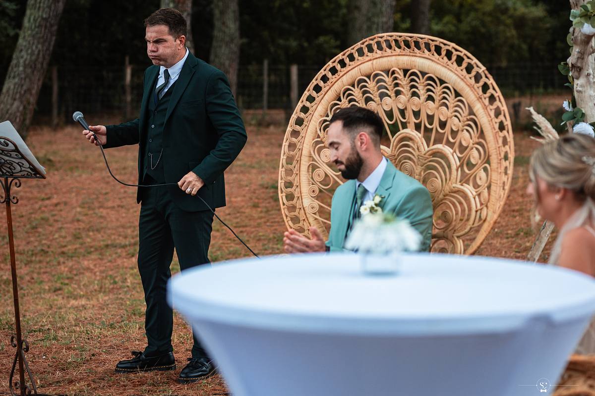 P&egrave;re de la mari&eacute;e tres &eacute;mu parlant au micro, devant un couple assis dans des chaises d&eacute;coratives en rotin, lors d'un mariage simple &agrave; N&icirc;mes