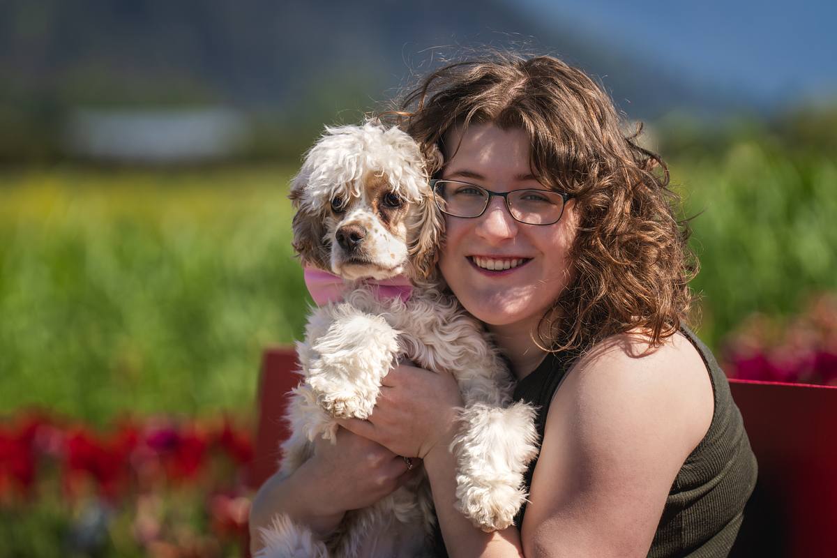 Young woman with her cocker spaniel at a tulip festival.