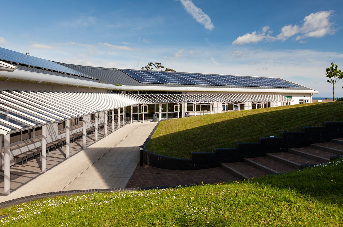 Architectural photograph of Penwith College restaurant building, Cornwall, with large windows and landscaped bank.