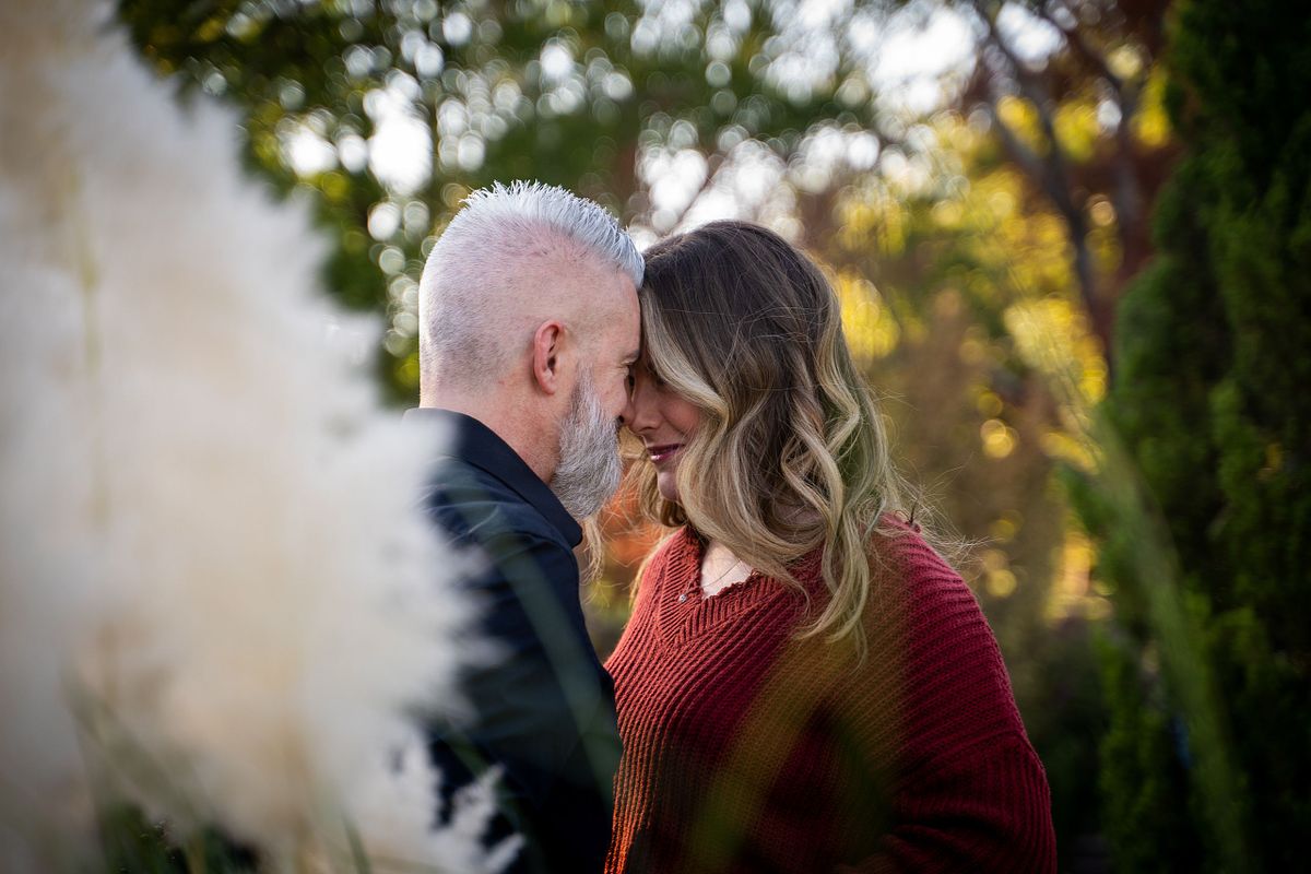 Engaged couple sharing a candid moment during golden hour in Oklahoma.