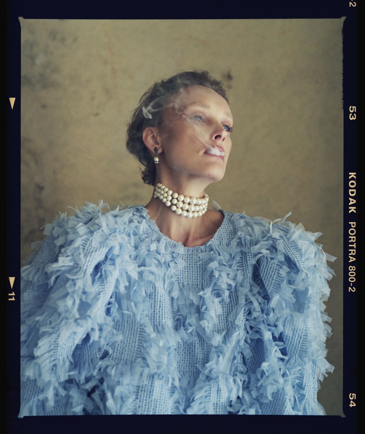 Analog fine art portrait of Laura from Letters from Mom series, shot on Kodak Portra 800 film, wearing a blue feathered sweater and pearl necklace, by Gabriel Matula.