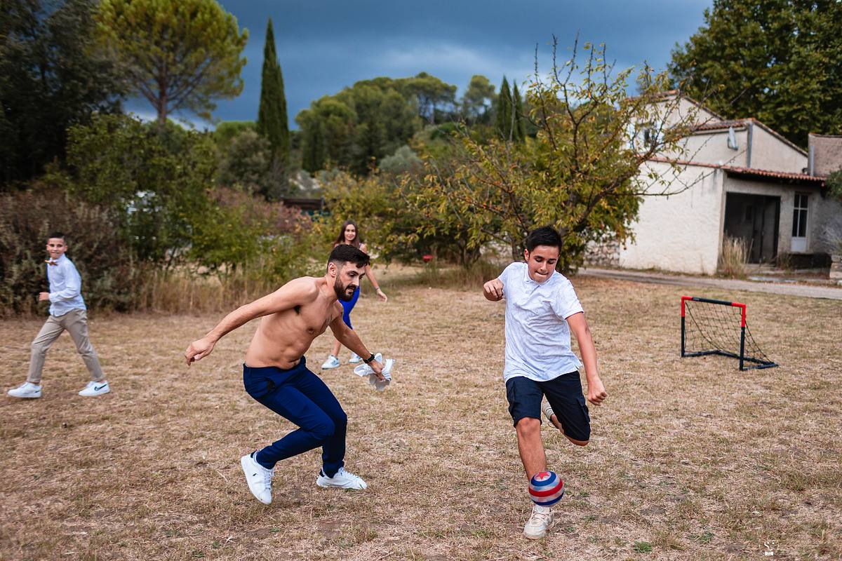 Jeunes invit&eacute;s jouant au football dans une ambiance d&eacute;tendue de mariage, sc&egrave;ne captur&eacute;e par S&eacute;bastien Clavel, photographe de mariage op&eacute;rant en France