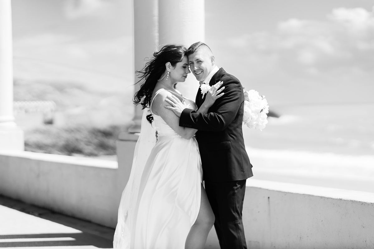 Black and white portrait of bride and groom embracing by the sea at Barry Island, photographed by Marta Vershynina South Wales wedding photographer