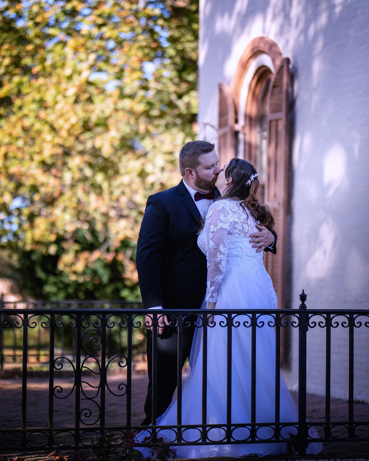 bride and groom kissing during golden hours at ross mansion standing on the terrace