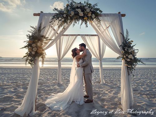 Bride standing beneath a floral wedding arch on Atlantic Beach in Jacksonville, Florida at sunset