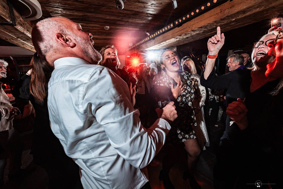 Cocktail et Soir&eacute;e de Mariage avec les invit&eacute;s et les mari&eacute;s qui s'amusent, sourient, s'embrassent et dansent. Les Rhodos La Clusaz Sebastien Clavel Photographe Mariage Lyon