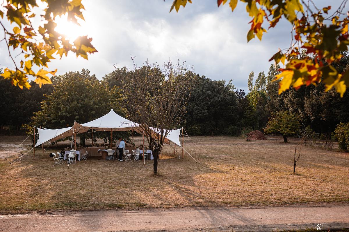 Tente de r&eacute;ception &eacute;clair&eacute;e par une lumi&egrave;re douce du soleil couchant dans une prairie de N&icirc;mes, photographi&eacute;e par S&eacute;bastien Clavel, photographe de mariage de Lyon