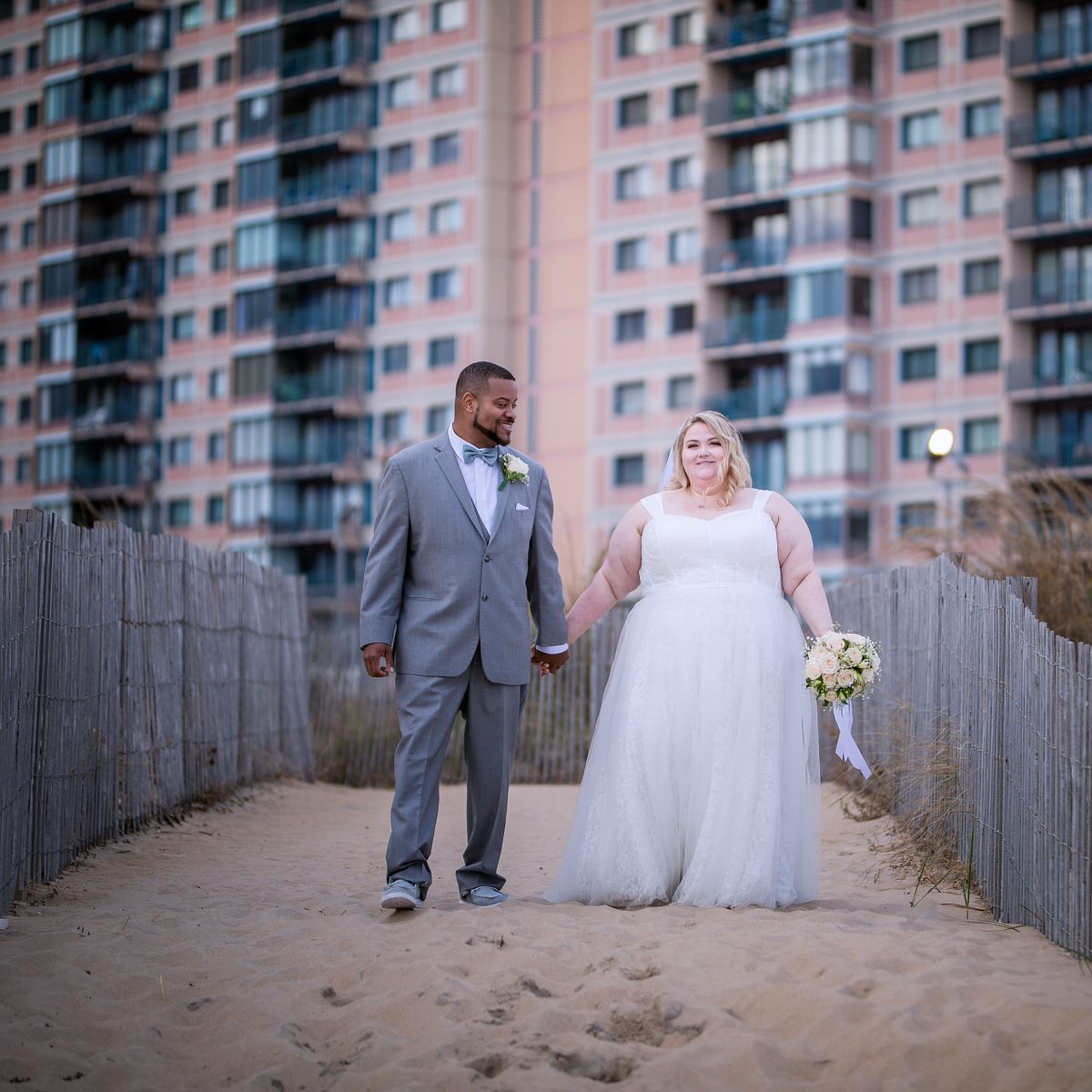 Documentary wedding photography of a couple walking through the windswept dunes of Cape Henlopen State Park in Lewes, Delaware, captured by Windswept Photo Design.