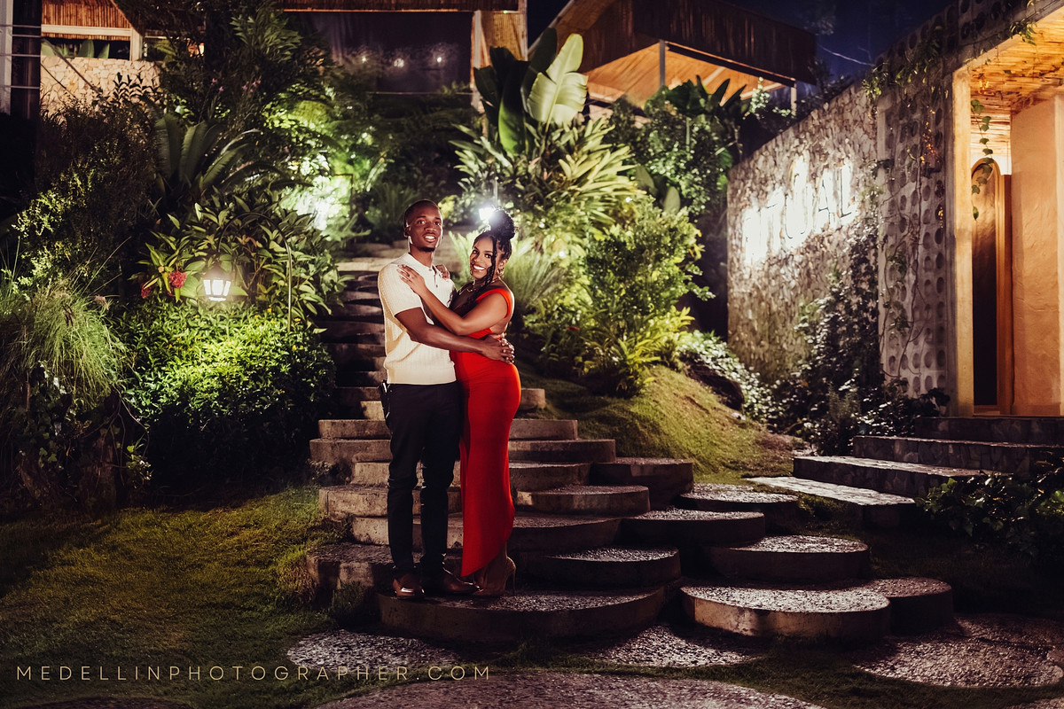 Couple on lit garden steps at night during an engagement photoshoot in Medellin