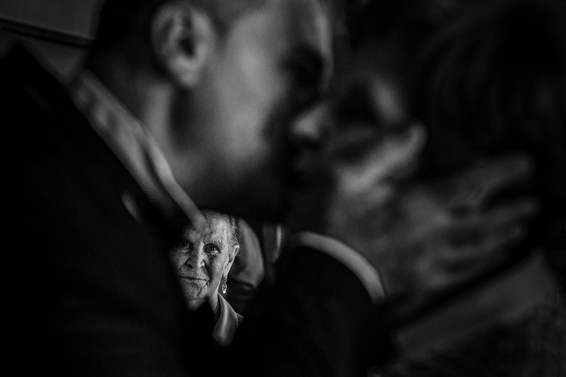 Grand-mère et marraine du marié regardant le marié embrasser sa maman