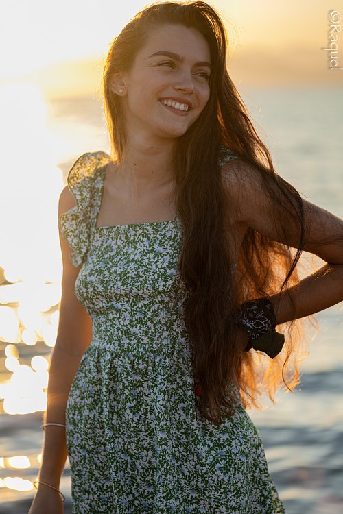 Jeune femme souriante photographiée au coucher du soleil sur la plage de l’Almanarre