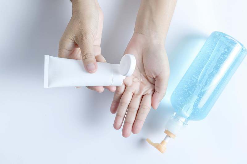 image of a woman applying hand lotion to hear hand