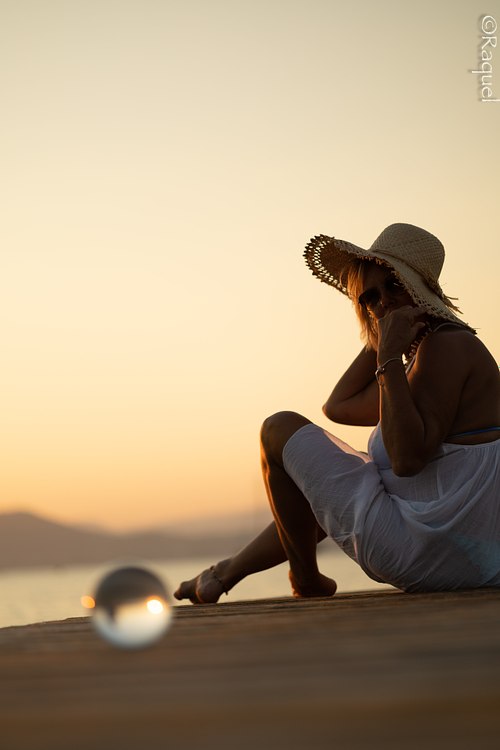 Portrait d’une femme assise en bord de mer à Hyères au coucher du soleil.