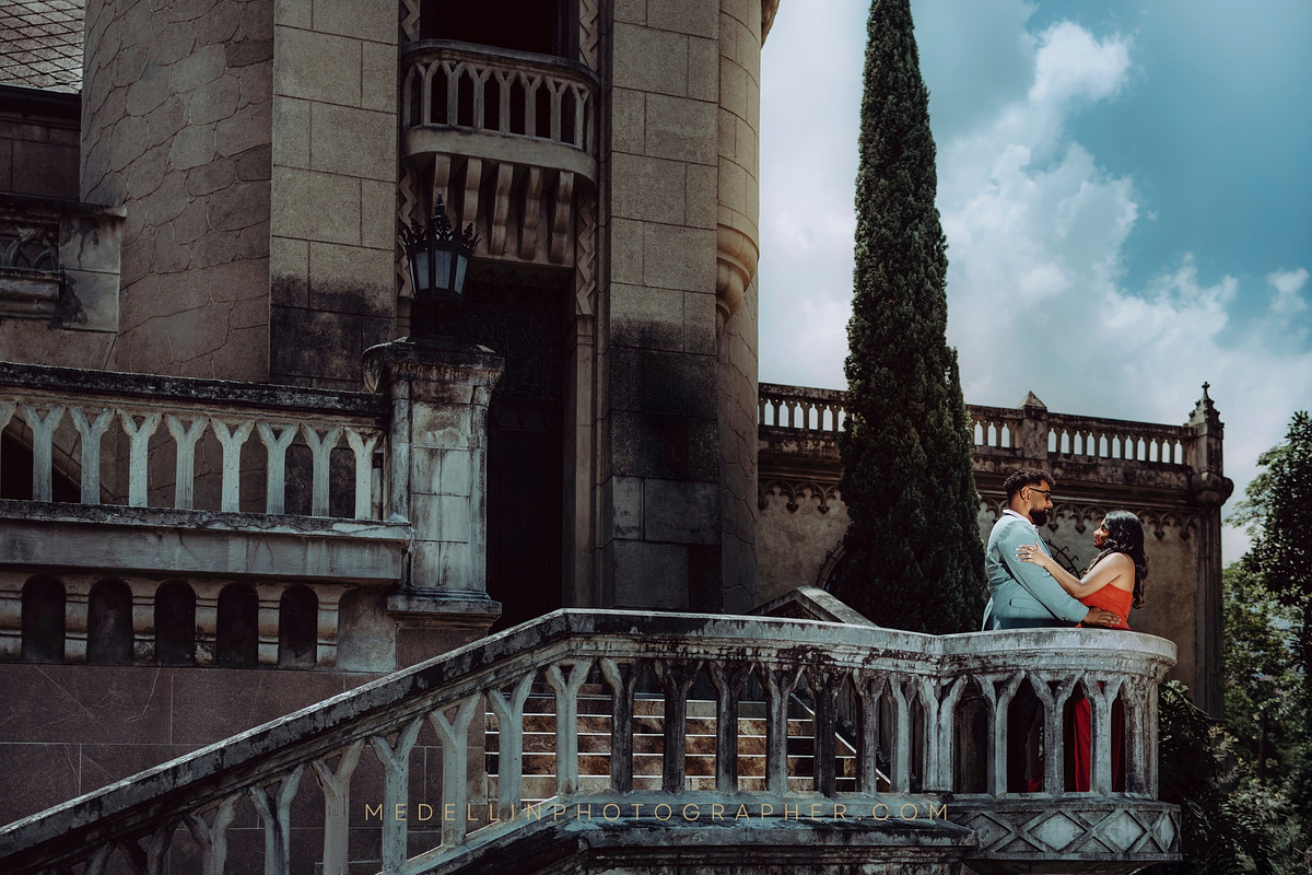 Afternoon engagement portrait on a stone balcony overlooking Medellin