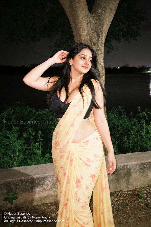 Nupur Ahuja in a floral yellow saree photographed under night street lighting with modern fashion styling