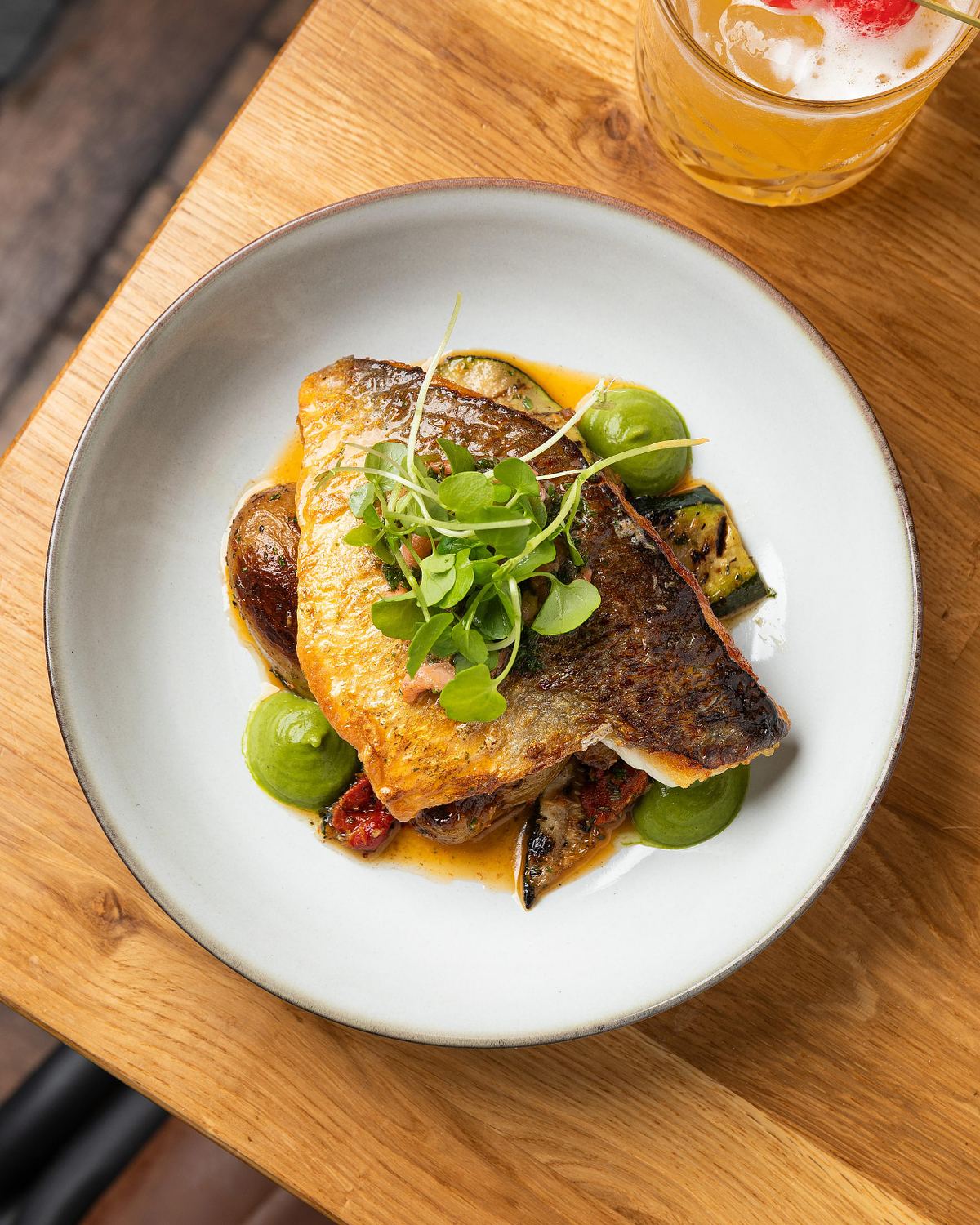 Overhead shot of a dish of fish on a bed of potatoes