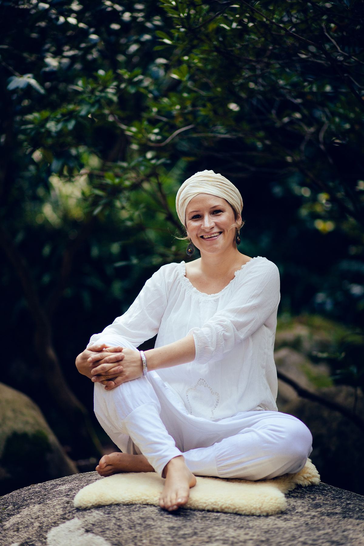 Woman in white sitting in a garden for a portrait