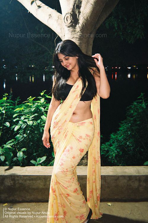 Nupur Ahuja wearing a floral yellow saree and black blouse in a cinematic night portrait
