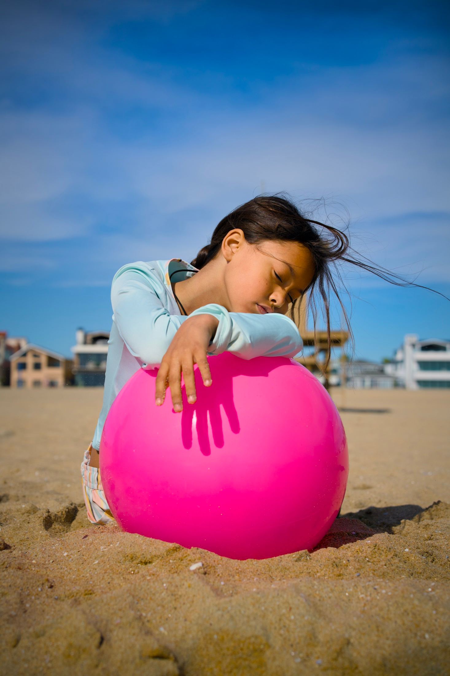 A child holding a luminous pink ball at Newport Beach