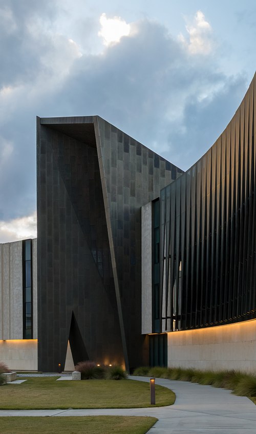 Exterior architectural photography of the L. Gale Lemerand Student Center at Daytona State College, featuring its iconic bronze portal and curved stone walls.
