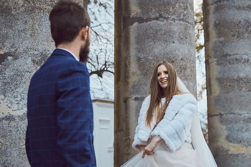 Elegant bridal portrait among historic architecture in Pidhirtsi