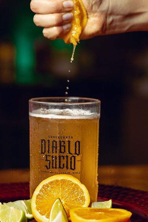 Vaso lleno de cerveza fría con naranja en barra de bar en Panamá