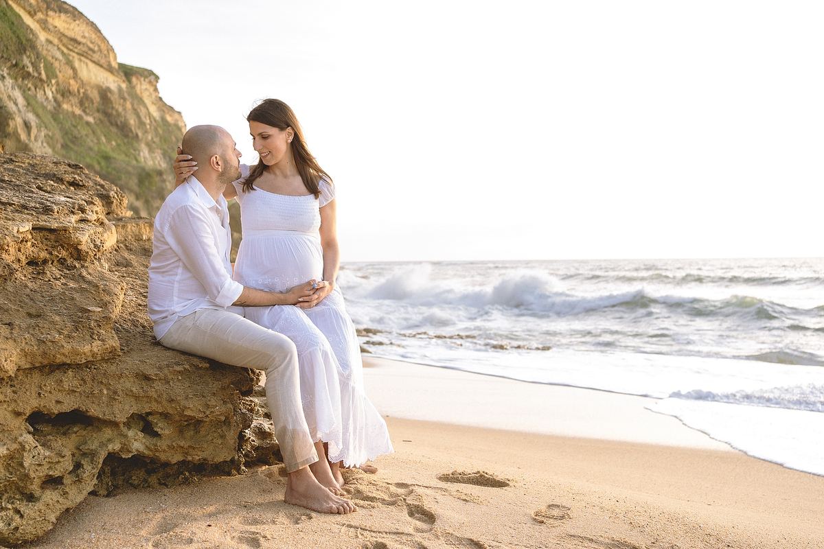 Couple sitting together on a rocky beach near Lisbon