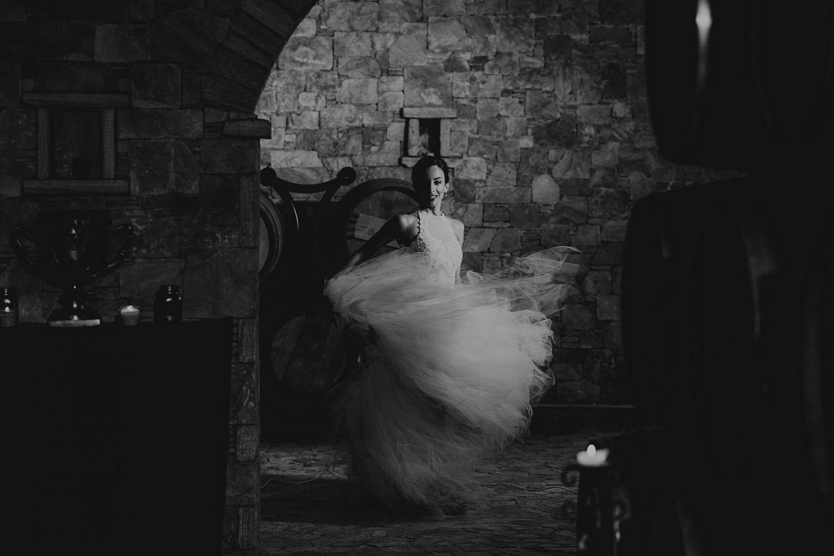 elegant bride in motion with wedding dress in luxury ch&acirc;teau cellar in Beaujolais France &ndash; editorial wedding photography