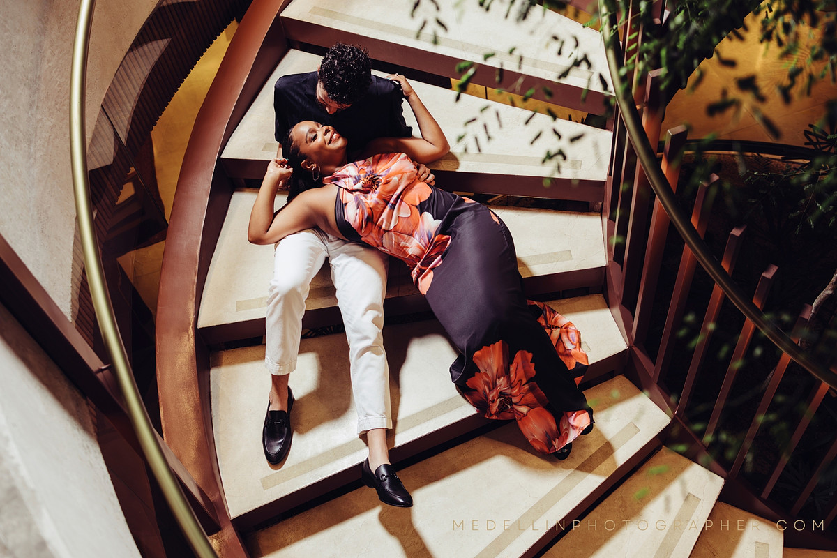 Overhead photo of a couple lying together on a spiral staircase in Medellin