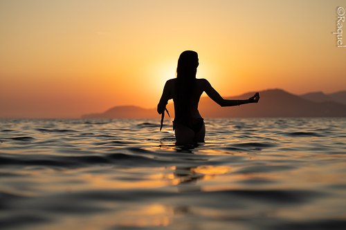 Silhouette d'une femme dans la Méditerranée au coucher du soleil à Hyères dans le Var.